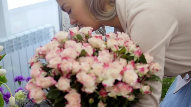 Florist prepares a bouquet of flowers for sale to customers in love. Floral design, floral arts, creating flower arrangements from cut flowers, foliages, herbs, ornamental grasses, plant materials.
