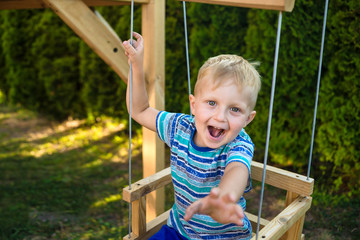 A small boy himself rolls on a seesaw without parental supervision