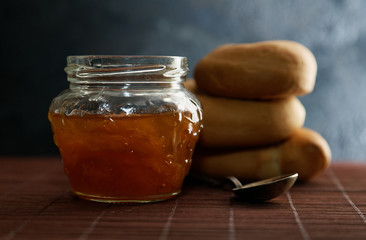 Jam jar and pretzel on the table close-up