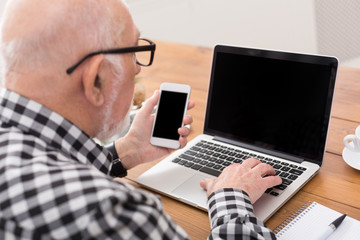 Fototapeta na wymiar Senior man using laptop and smartphone mockup