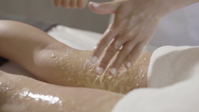 Girl treatment massage honey body wrap in a beauty salon
