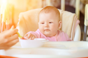 A cheerful happy child eats porridge.