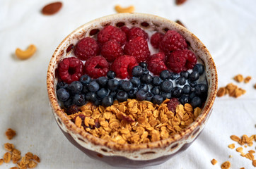Bowl of homemade granola with yogurt and fresh berries on white background. Top view. Collection