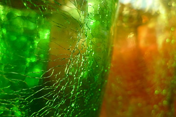 Close-up green and pink glass  texture with crackles . Glass reflecting light.