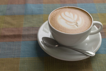 Coffee cup latte art with tree shape foam top view on wooden table background in coffee shop