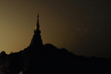 Silhouette of pagoda  buddhism against golden night sky with stars