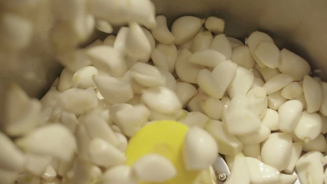 Falling peeled garlic into blander. 4Ksuper slow