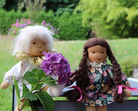 Zwei Puppen im Garten - Mädchen mit Schutzengel