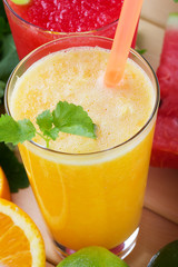Smoothies from orange and tangerine and smoothie from watermelon with mint on wooden background