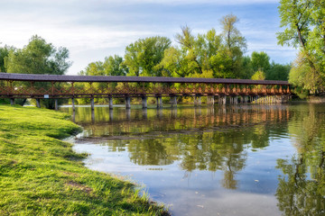 Fototapeta premium Wooden pedestrian bridge over river in Kolarovo, Slovakia
