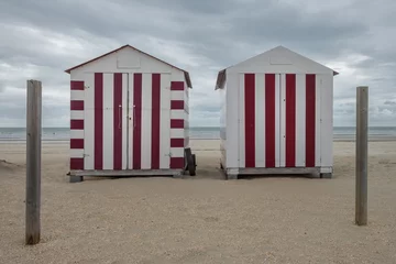  Two colorful beach cabins on a cloudy day in De Panne, Belgium. © Erik_AJV