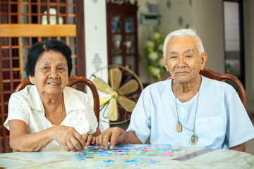 Couple senior playing with a jigsaw puzzle at home