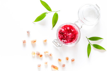Raspberry jam in glass jar on white background top view copyspace