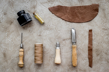 Fototapeta na wymiar Set of leather craft tools on grey stone background top view mockup