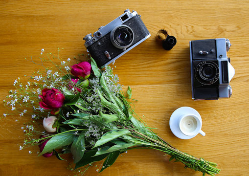 vintage camera near a bouquet of flowers and candles