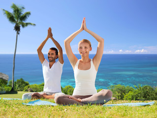 couple doing yoga in lotus pose outdoors