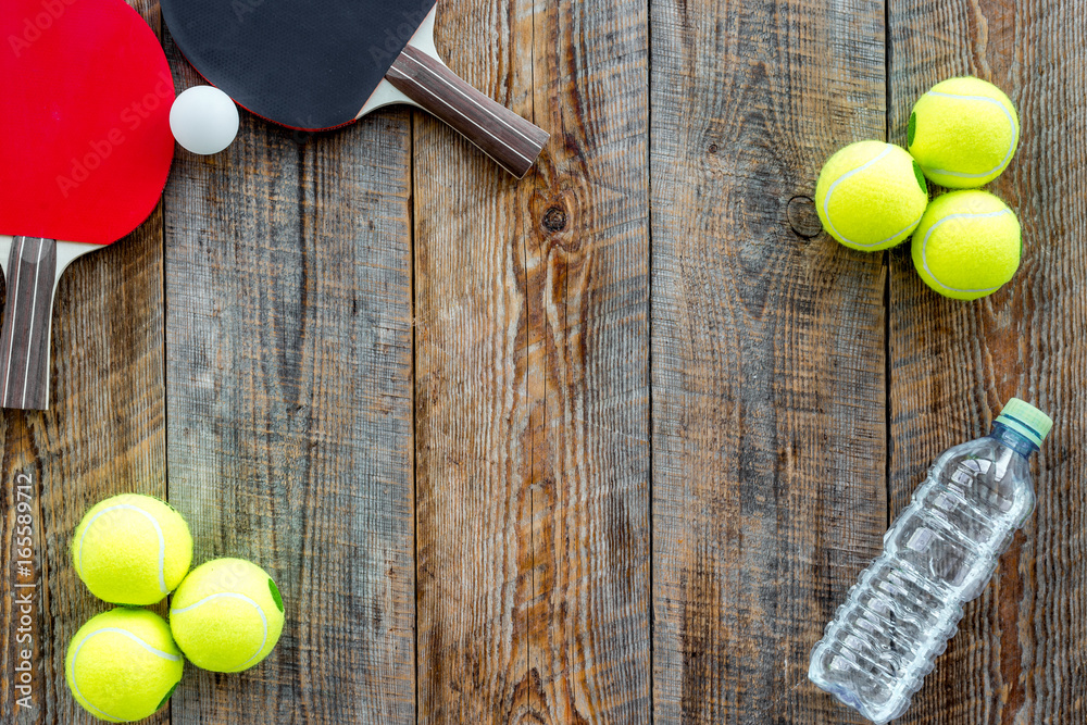 Wall mural sport background. sport gear. table tennis racket, tennis balls on wooden background top view copysp