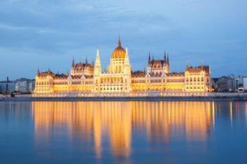 Fototapeta na wymiar The building of Parliament with reflection in the river in Budapest at sunset