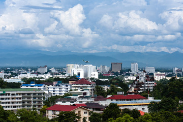 High-angle view of the city with buildings, airports, and mountains in the background.