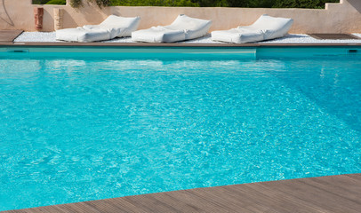 bequeme Matratzen zum ausspannen am Pool mit türkisem Wasser