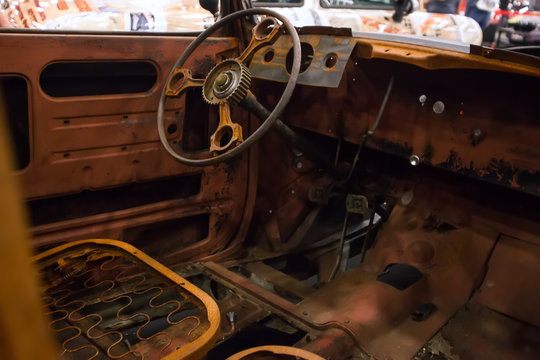 Rusty interior of an old car. Close up of Car steering wheel and dashboard panel with rust and dust.