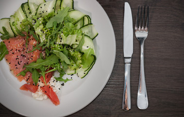 Meat of trout on a plate with vegetables and grapefruit