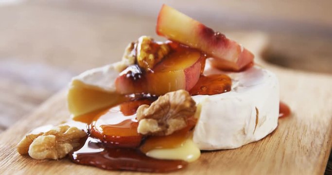 Cheese topped with walnut, fruits and sauce