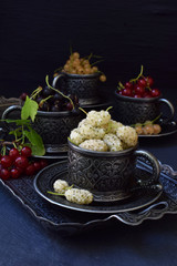 Composition of fresh ripe berries: red, black and white currant, mulberry on a dark gray concrete background. Dark photo. Photographing in natural light. Space for your text