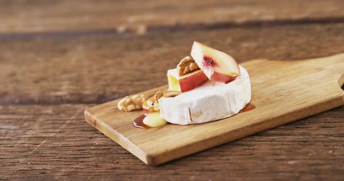 Cheese topped with walnut, fruits and sauce