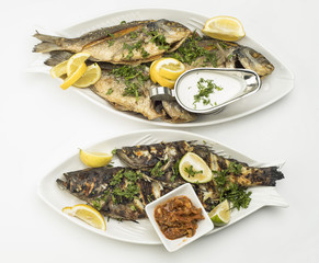 Grilled Fish with Lemon Slices, Grilled seafood served on plate isolated on white