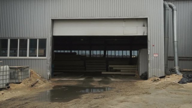 Roller shutter door and concrete floor inside factory building for industrial background. The open door of the hangar