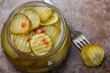 Slices of pickled cucumbers with pepper and mustard in a jar. Snack for gourmets. Selective focus © la_vanda