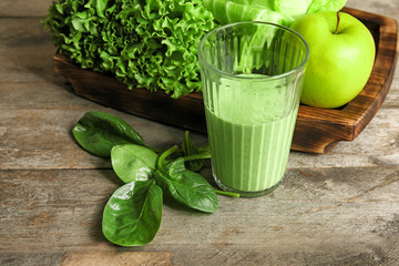 Glass of fresh juice on wooden background
