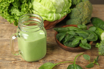 Mason jar of fresh juice on wooden background