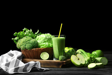 Glass of fresh vegetable juice on wooden table