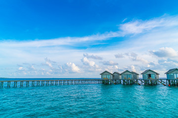 Beautiful water villas in tropical Maldives island at the sunset time .