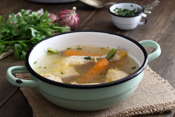 brodo o zuppa  con cosce di pollo in tegame di metallo