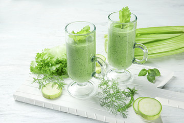 Glasses of fresh juice and ingredients on wooden background