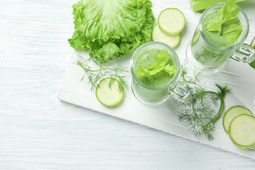 Glasses of fresh juice and ingredients on wooden background