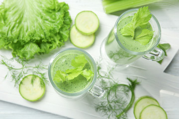 Glasses of fresh juice and ingredients on wooden background