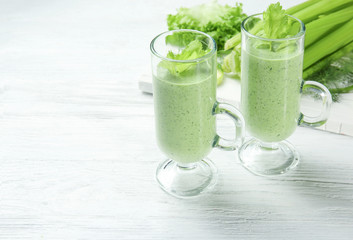 Glasses of fresh vegetable juice on wooden background