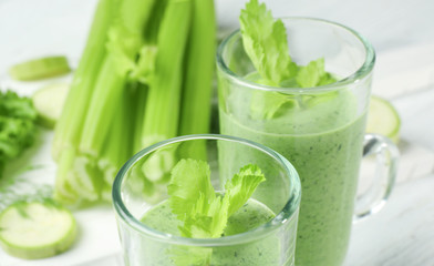 Glasses of fresh vegetable juice on white table
