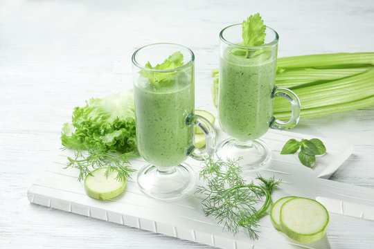 Glasses of fresh juice and ingredients on wooden background