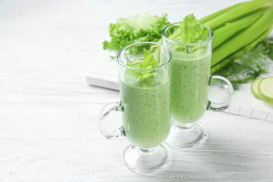 Glasses of fresh vegetable juice on wooden background