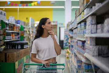 Beautiful young woman shopping in a grocery store supermarket