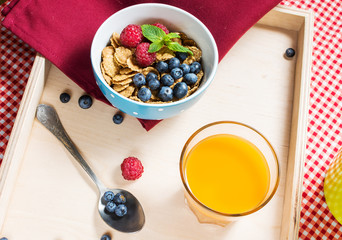 Multigrain wholewheat healthy cereals with fresh berry and a glass of juice for breakfast