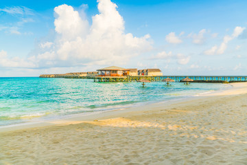 Beautiful water villas in tropical Maldives island at the sunrise time .
