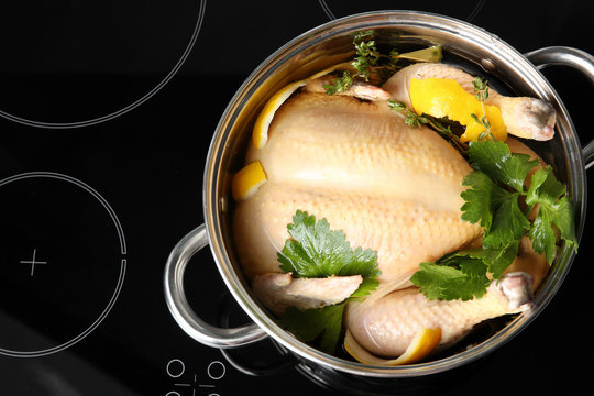 Cooking pot with turkey soaked in flavored brine on electric stove