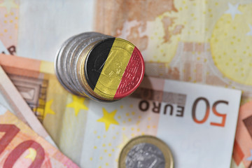 euro coin with national flag of belgium on the euro money banknotes background © luzitanija
