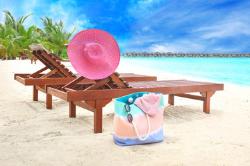 Wooden sun loungers with beach accessories at sea resort